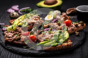 Sandwich tuna fish collection. Delicious breakfast or snack. Toasts with tuna delicious healthy food on a dark background, Top