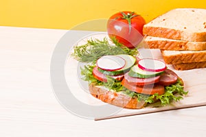 a sandwich of vegetables and diet sausages on the table