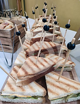 Sandwich on wooden skewers. The filling of the sandwich consists of bacon, cheese and salad