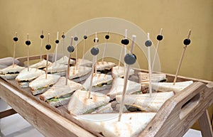 Sandwich on wooden skewers. The filling of the sandwich consists of bacon, cheese and salad