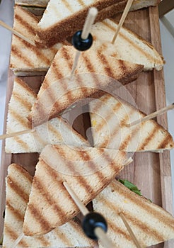 Sandwich on wooden skewers. The filling of the sandwich consists of bacon, cheese and salad