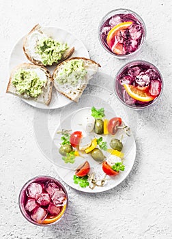 Sandwiches with avocado, canape with mozzarella, tomatoes, olives and aperol spritz