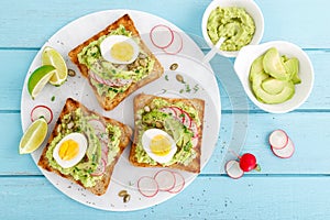 Sandwiches with avocado guacamole, fresh radish, boiled egg, chia and pumpkin seeds. Diet breakfast. Delicious and healthy plant-b