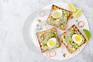 Sandwiches with avocado guacamole, fresh radish, boiled egg, chia and pumpkin seeds. Diet breakfast. Delicious and healthy plant-b photo
