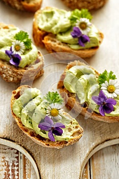 Sandwiches with avocado paste with the addition of edible flowers