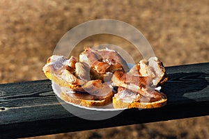 Sandwiches with Baikal omul on a white round plate.