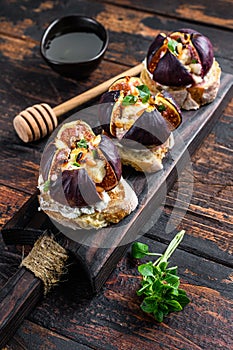 Sandwiches with baked figs, jam and cream cheese. Wooden background. Top view