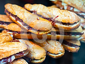 Sandwiches bocadillo from baguette with jamon behind display glass photo