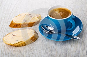 Sandwiches with cheese, coffee in cup, spoon on saucer on table