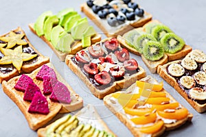 Sandwiches with cream cheese, chocolate, fresh fruits and berries avocado, blueberries, bananas, kiwi, cherry, apricot, dragon