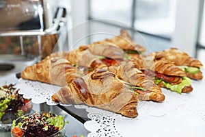Sandwiches croissants on the buffet table. Coffee break and business meetings. Close-up