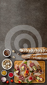 Sandwiches on a dark background, or assorted canapes or pintxos, tapas. Copy space. Concept party food or blog