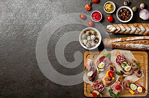 Sandwiches on a dark background, or assorted canapes or pintxos, tapas. Copy space. Concept party food or blog