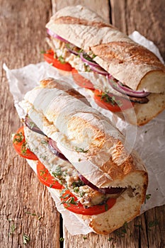 Sandwiches with fried mackerel and vegetables close-up. vertical