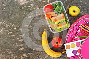 Sandwiches, fruits and vegetables in food box, backpack on old wooden background.