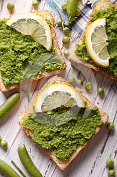 Sandwiches with green peas and lemon closeup. vertical top view