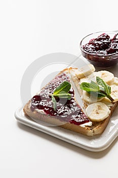 Sandwiches for healthy and sugar-free children`s breakfast with berry jam, bananas