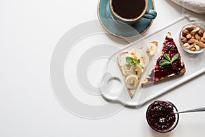 Sandwiches for healthy and sugar-free children`s breakfast with berry jam, bananas