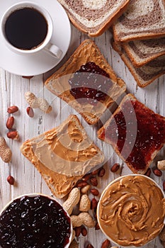 Sandwiches with jam, peanut butter and coffee top view