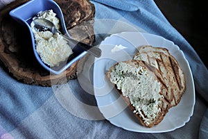 sandwiches from a loaf and with cheese paste on a wooden stand and in a white plate