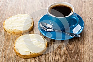 Sandwiches with melted cheese, coffee in cup, spoon on saucer on