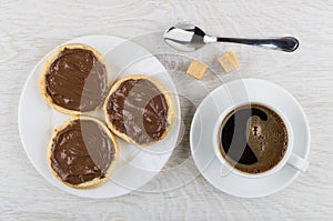 Sandwiches with nut-chocolate paste in plate, black coffee, sugar