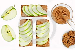 Sandwiches with peanut butter and an apple on the table close-up. Apple slices, walnuts isolated on white background. Horizontal