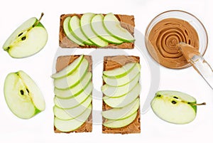 Sandwiches with peanut butter and an apple on the table close-up. Apple slices, walnuts isolated on white background. Horizontal