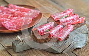 Sandwiches with salami on the wooden board