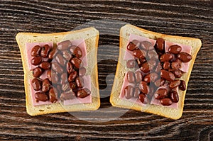 Sandwiches with sausage and lobio on wooden table. Top view