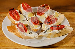 sandwiches with sun-dried tomatoes and cheese on a plate on the table