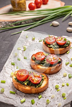 Sandwiches on toasted white bread with spinach cheese decorated with tomato slices. Selective focusing