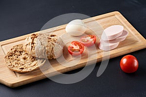 Sandwiches with tomatoes, eggs and mayonnaise on a wooden plate