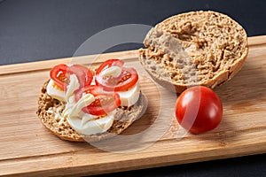 Sandwiches with tomatoes, eggs and mayonnaise on a wooden plate