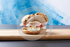 Sandwiches with tomatoes, eggs and mayonnaise on a wooden plate