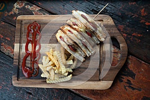 Sandwiches with Turkish sausage sucuk and cheese served aise with french fries on rustic wooden table