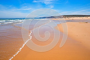 Sandy bay Praia do Bordeira with outgoing waves, portugal coast algarve