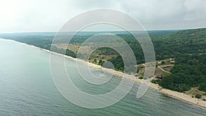 Sandy beach along forest shoreline, aerial drone view of Stenshuvud nature reserve in southern Sweden