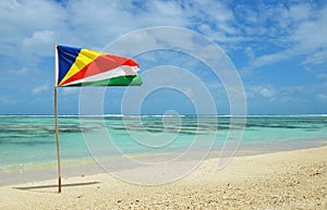 Sandy beach Anse Source d`Argent with flag of Seychelles in the La Digue Island.