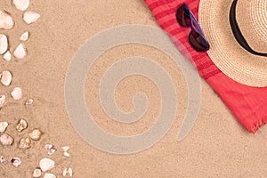 Sandy beach background, sunglasses, hat seashells