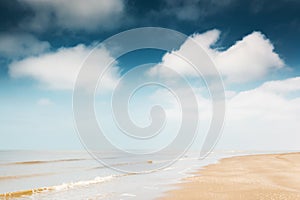 Sandy beach and blue sky with clouds.