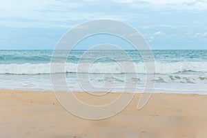 sandy beach blue sky and white formy wave