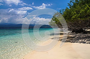 Sandy beach with blue water on the tropical island of Gili Meno. The mountains of Lombok on the horizon