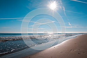 sandy beach of the Bolearic sea with beautiful waves against the background of a sunny sky