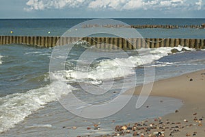 Sandy beach with breakwaters on the background of the sea1