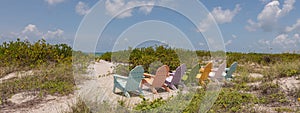 Sandy beach with colorful beach sunbeds, on a sunny day, with a sea view in the background