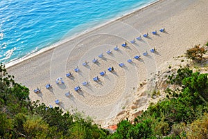 Sandy beach with empty sunbeds from above