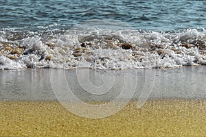 Sandy beach and foamed sea water