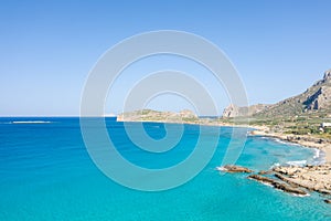 The sandy beach at the foot of the rocky cliffs in the arid countryside , in Europe, Greece, Crete, towards Kissamos, towards