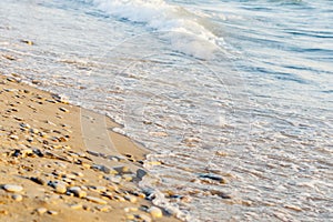 Sandy beach with the incoming waves sand and pebbles